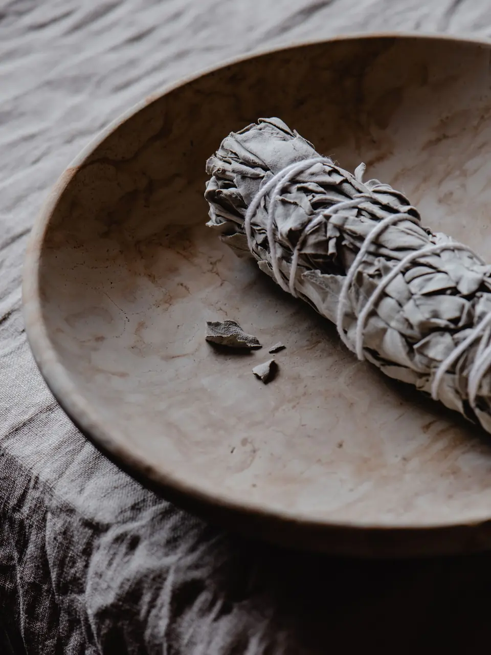 A white sage bundle on a wooden dish