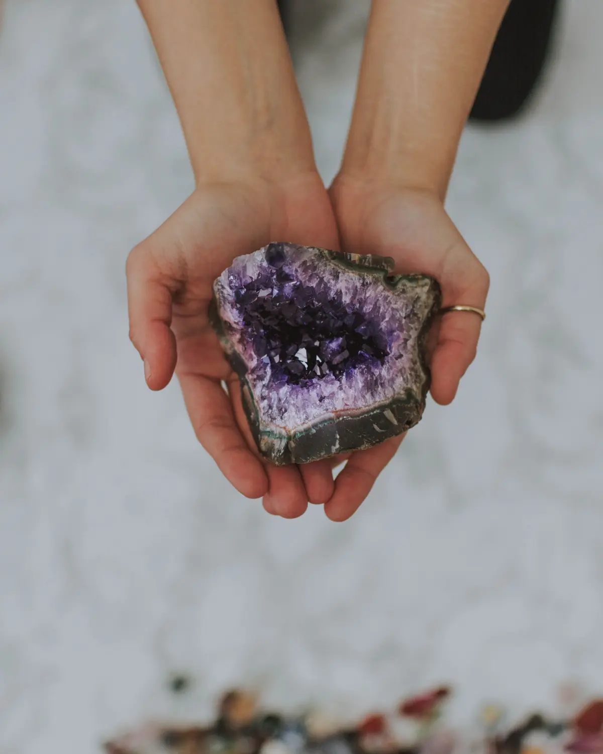 Two hands holding an open amethyst geode