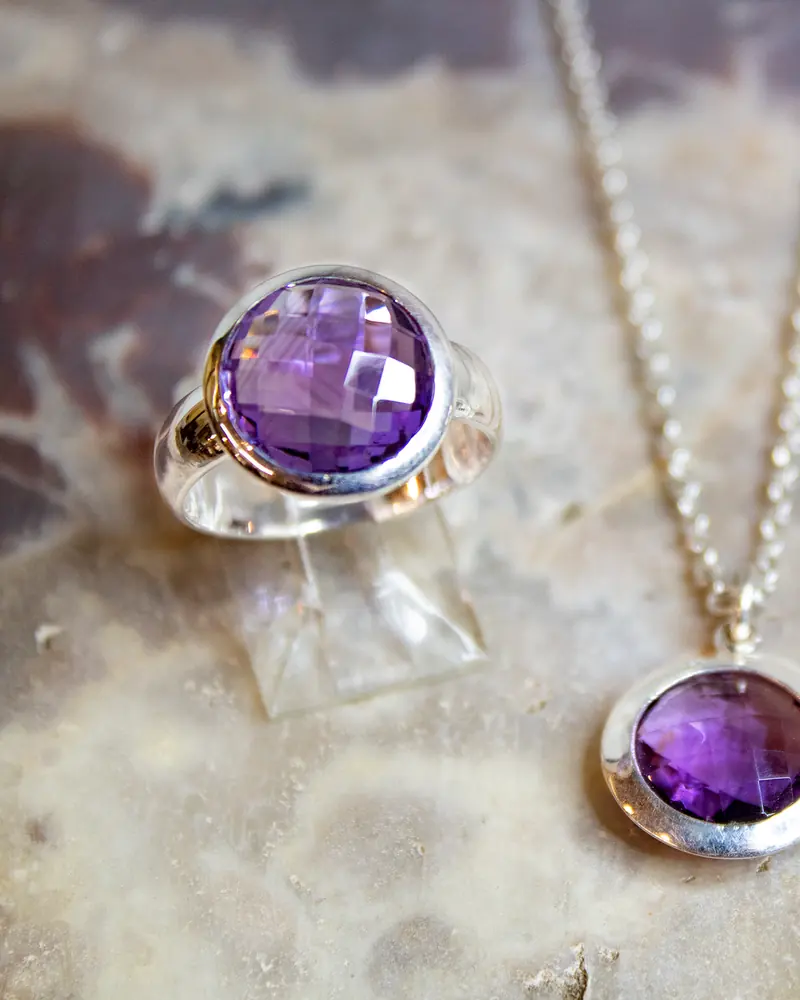A sterling silver ring set with a faceted amethyst