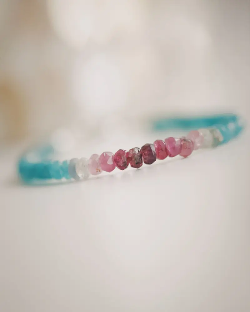 A delicate bracelet of faceted pink and blue gemstone beads