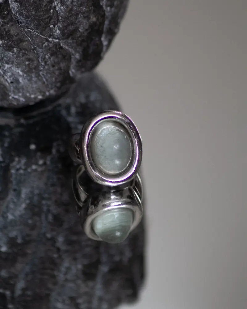 A sterling silver ring with an oval grey-green gemstone