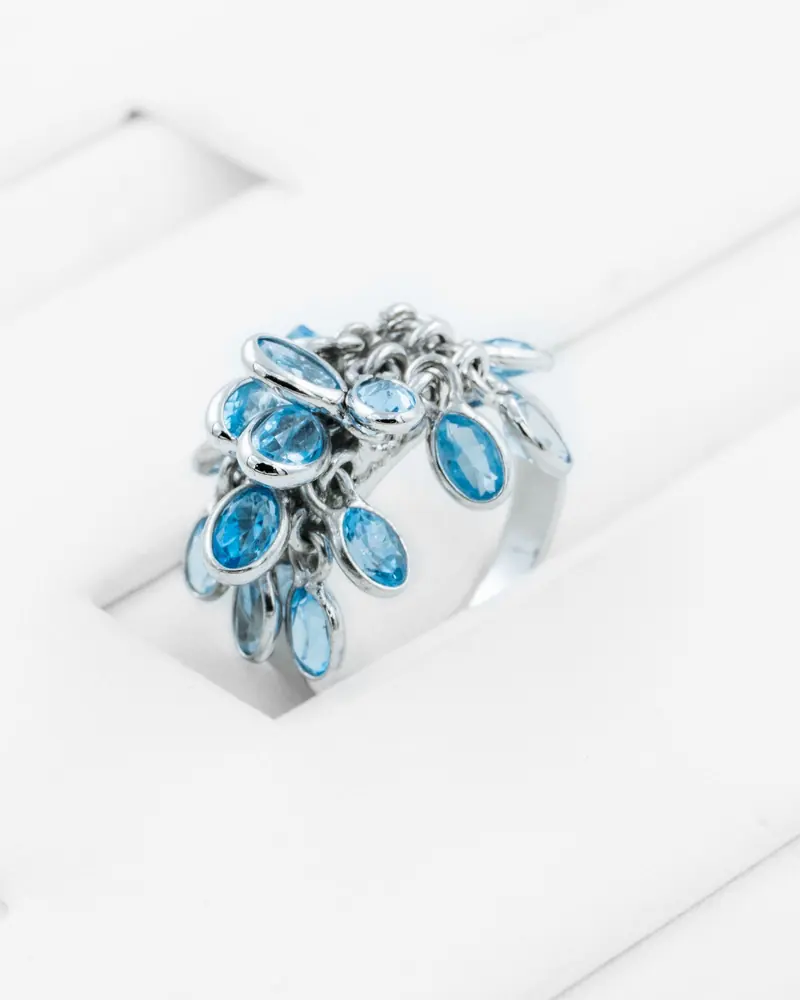 A sterling silver ring with dangling blue gemstones