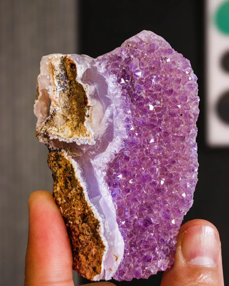 A small amethyst geode held between fingers