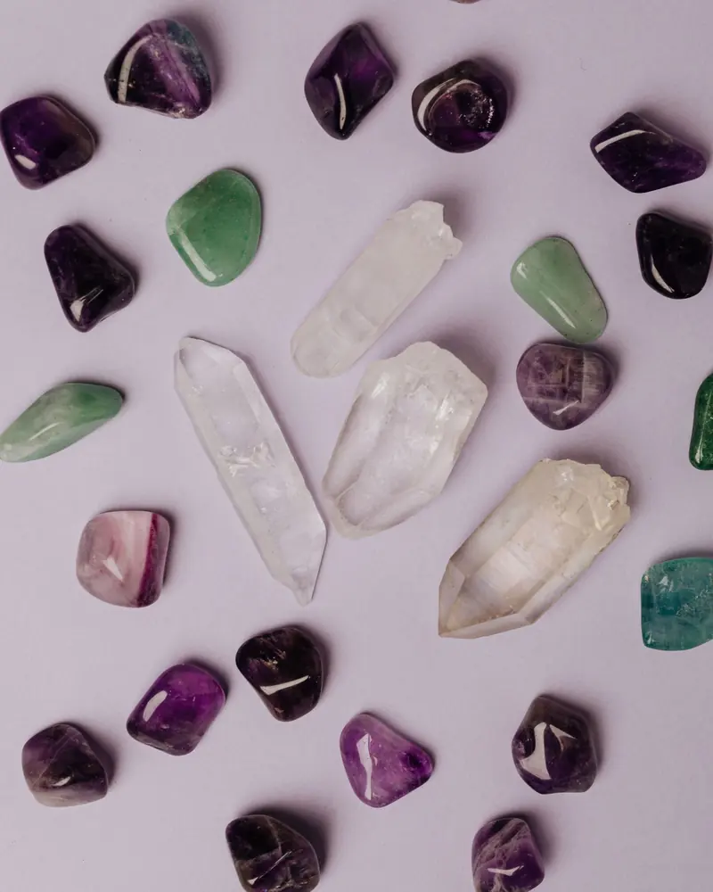 Tumbled amethyst, clear quartz points and green stones on lilac
